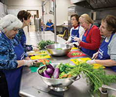 Photo of women preparing food in a kitchen. Links to Gifts of Cash, Checks, and Credit Cards