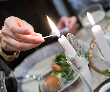 Photo of a person lighting a candle. Links to Gifts That Pay You Income