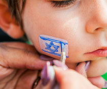 Photo of a boy getting the jewish flag painted on his cheek. Links to Gifts That Protect Your Assets Photo of a boy getting the jewish flag painted on his cheek. Links to Gifts That Protect Your Assets